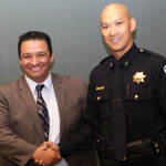 Twin Rivers USD Superintendent Dr. Steven Martinez, left, congratulates Harvey Woo, right, the district’s new police chief.