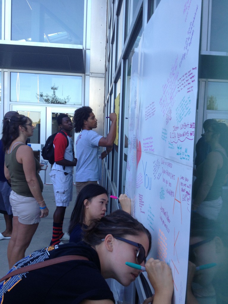 Students leave messages for Dylan Akins and his families on posters from teammates and classmates.
