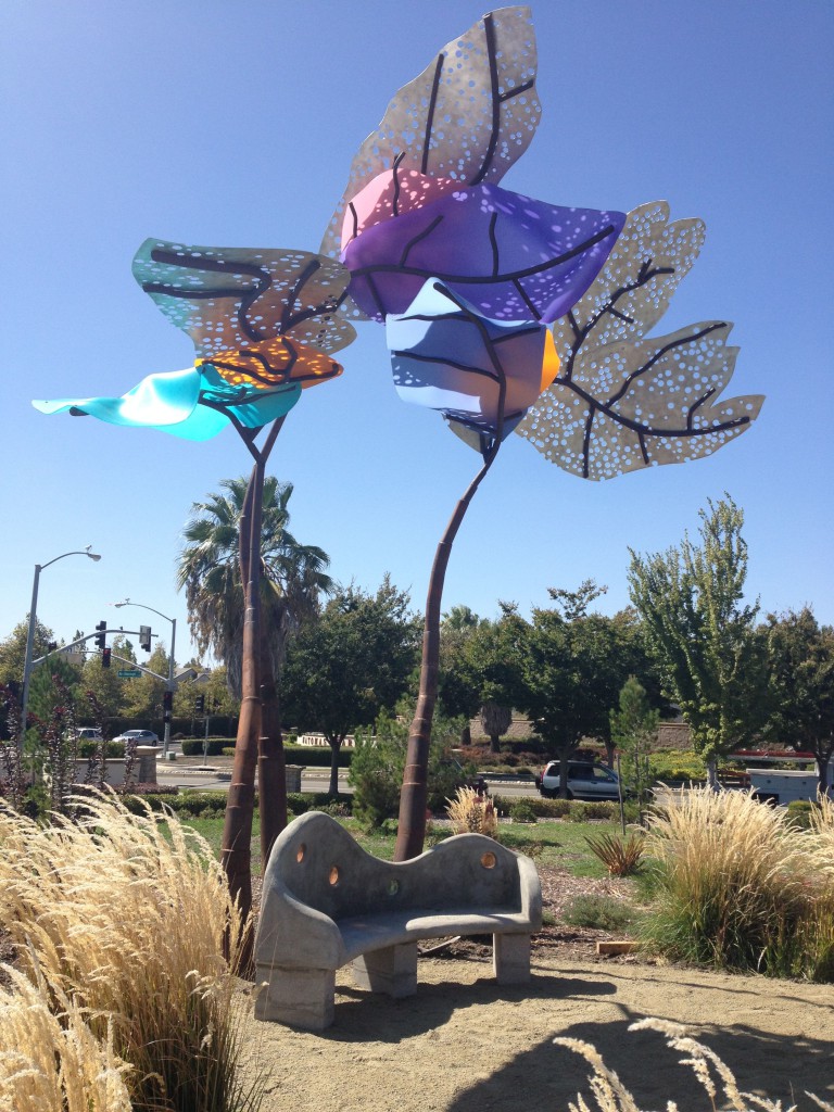 Image of large flower like sculptures with a sculpted bench positioned underneath.