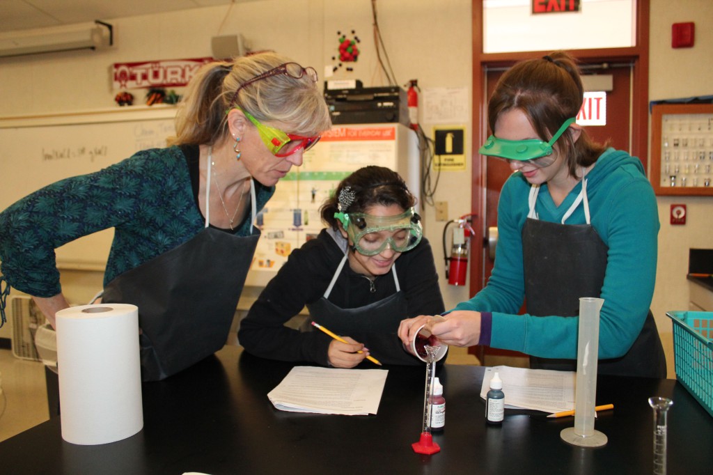 Chemistry teacher Ms. Rachel Kanowsky oversees an experiment being conducted by Cristal Vasquez (middle) and Olesiya Driga (2012).