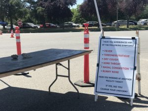 A sign with a list of questions about whether workers have any symptoms of illness and changed their uniform.