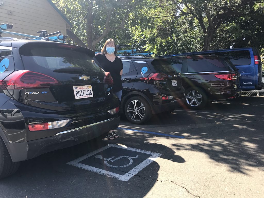 Image of four black cars parked in a row. The first two have the bright blue GIG logo.