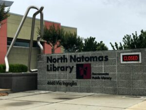 Image of North Natomas library branch sign with neon words which read "closed" in red.