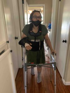 Image of woman using walker with right arm in brace.