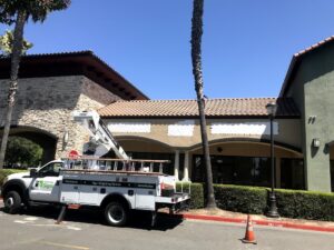 Image of truck with crane preparing to add sign to building that will house dance school in Natomas.