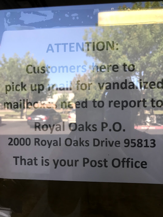 Image of sign with directions to pick up held mail at the main branch on Royal Oaks Drive.