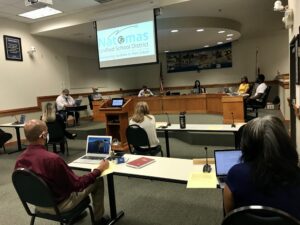 Image of five board members sitting at dias spaced apart from each other.