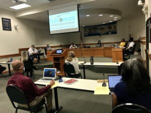 Image of five board members sitting at dias spaced apart from each other.