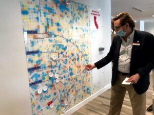 Image of man pointing to wall sized map.