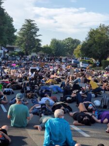 Image of hundreds of people lying down on the street.