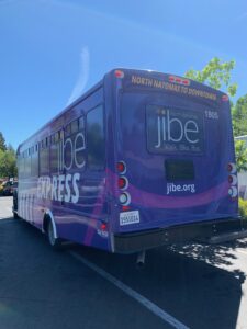 Image of side view of purple Jibe Express shuttle bus.