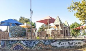 Image of playground with words "Fort Natomas" on a tile wall.