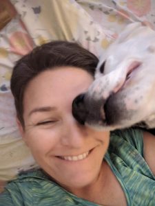 Image of woman with a dog resting on her face.
