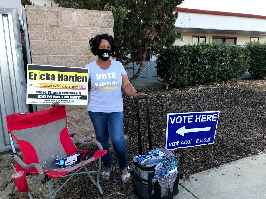 Image of Ericka harden holding campaign signs on Election Day.