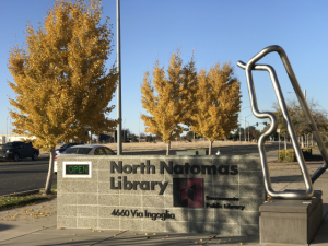 Image of North Natomas library branch sign with neon words which read "closed" in red.