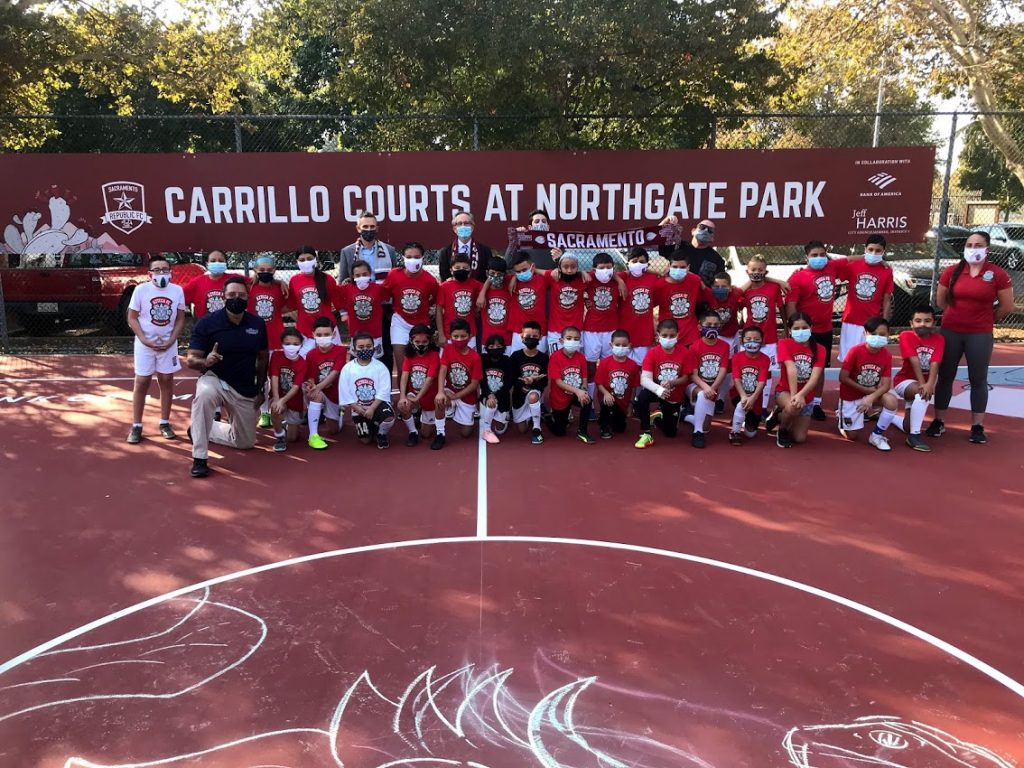 Image of large group in front of sign.