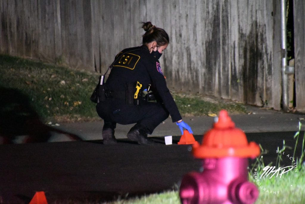 Image of police officer placing evidence markers on the ground.