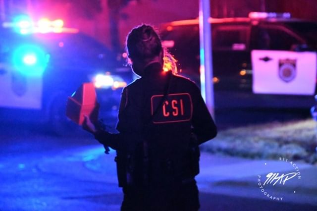 Image of back of police officer wearing CSI vest.
