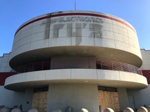 Image of round cement building with shadow of previous signage reading Fry's Electronics.