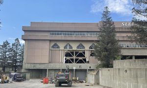 Image of five-story concrete building. There are open areas where part of the building has been demolished by wrecking crews.