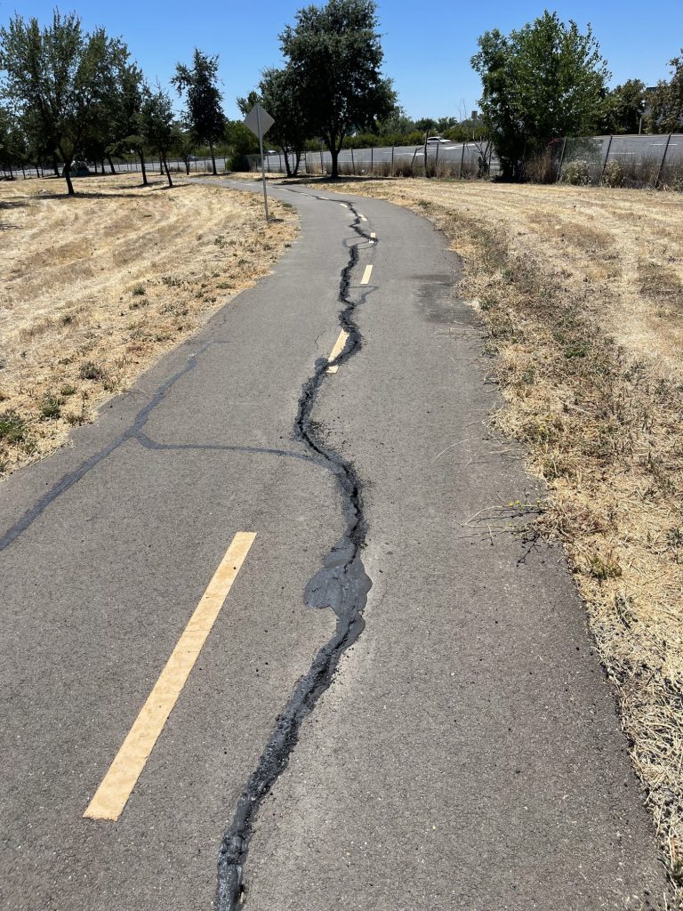 Image of a length of paved trail with visible cracks.