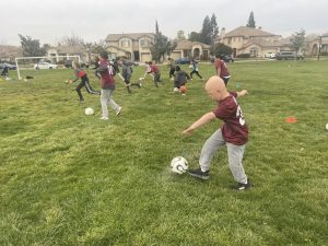 Images of several young people on a field of grass. Some are visibly kicking soccer balls.